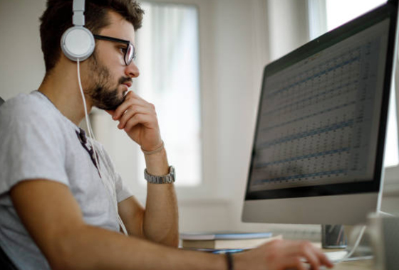 Man wearing headphones working at a computer