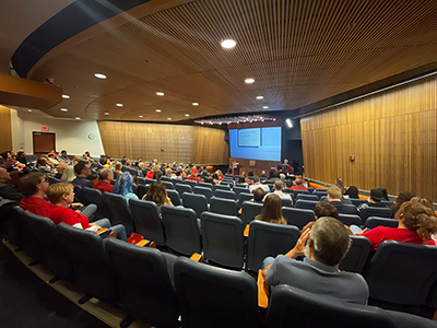 people sitting in a large auditorium space