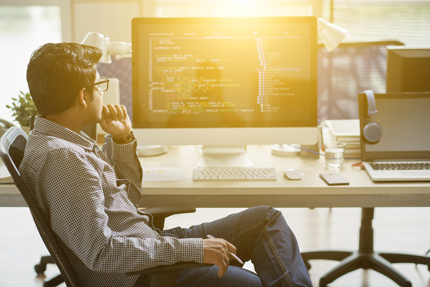 Man in contemplation in front of a computer with code